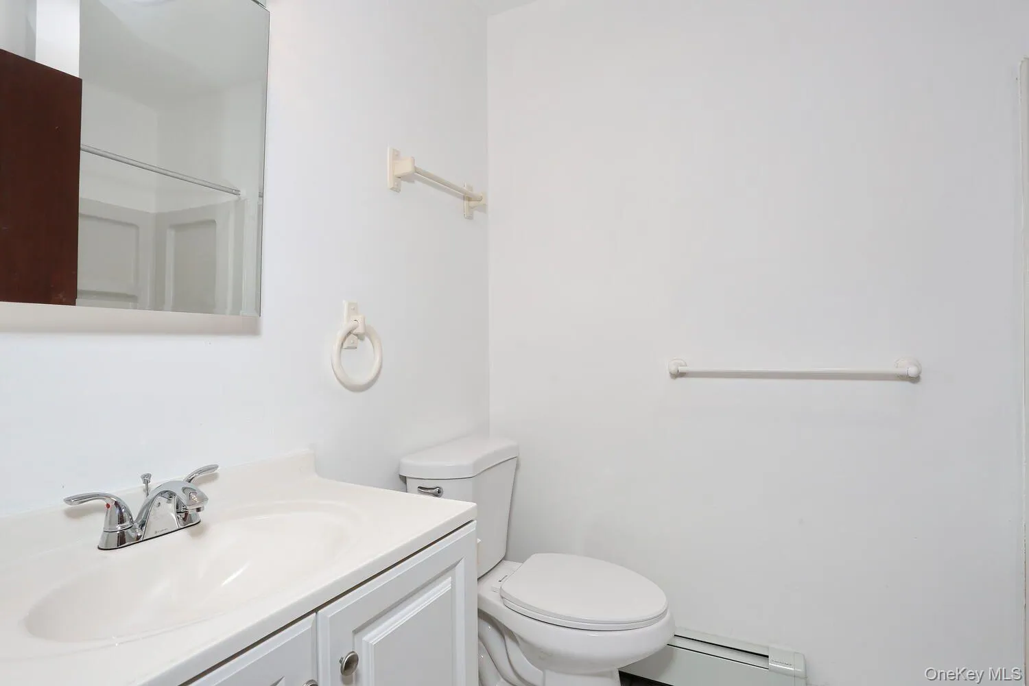 Full bath with vanity, baseboard heating, and a shower Full bath with vanity, baseboard heating, and a shower