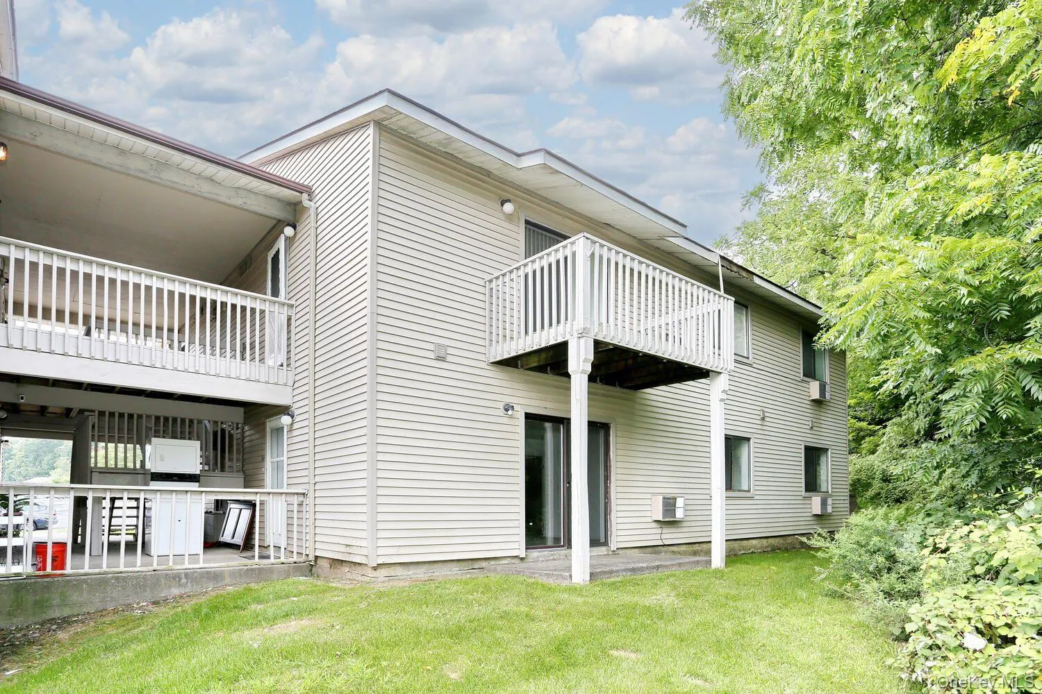 Rear view of house with a yard and a balcony Rear view of house with a yard and a balcony