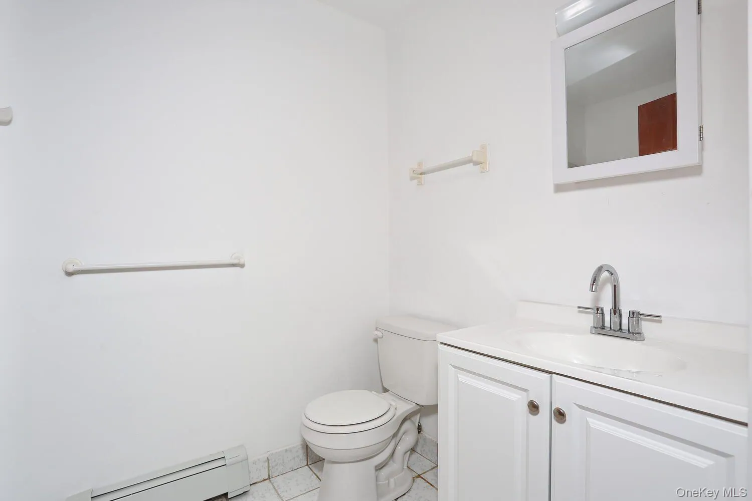 Half bath with baseboard heating, light tile patterned floors, and vanity Half bath with baseboard heating, light tile patterned floors, and vanity