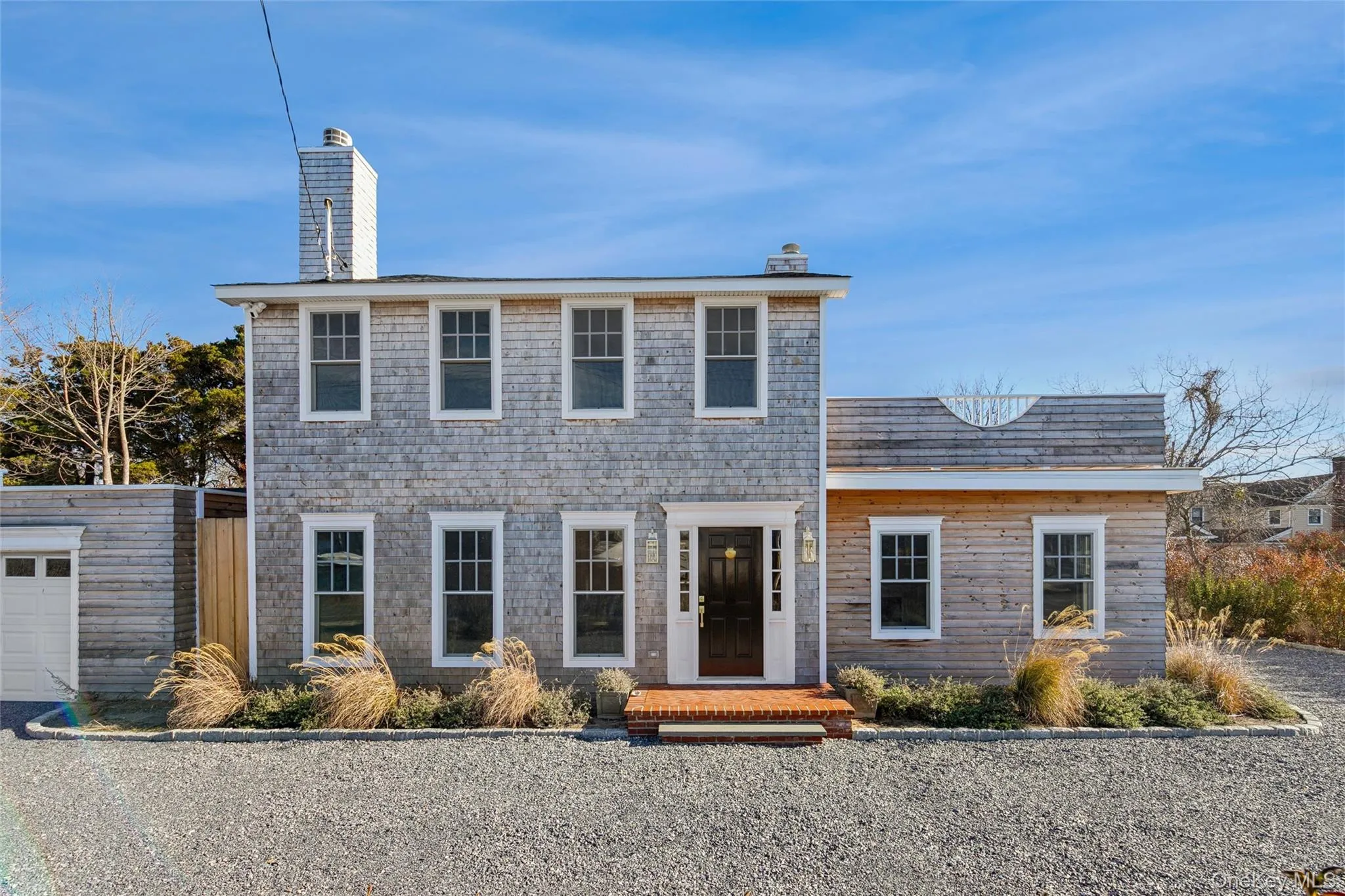 Colonial home with a chimney and a garage Colonial home with a chimney and a garage