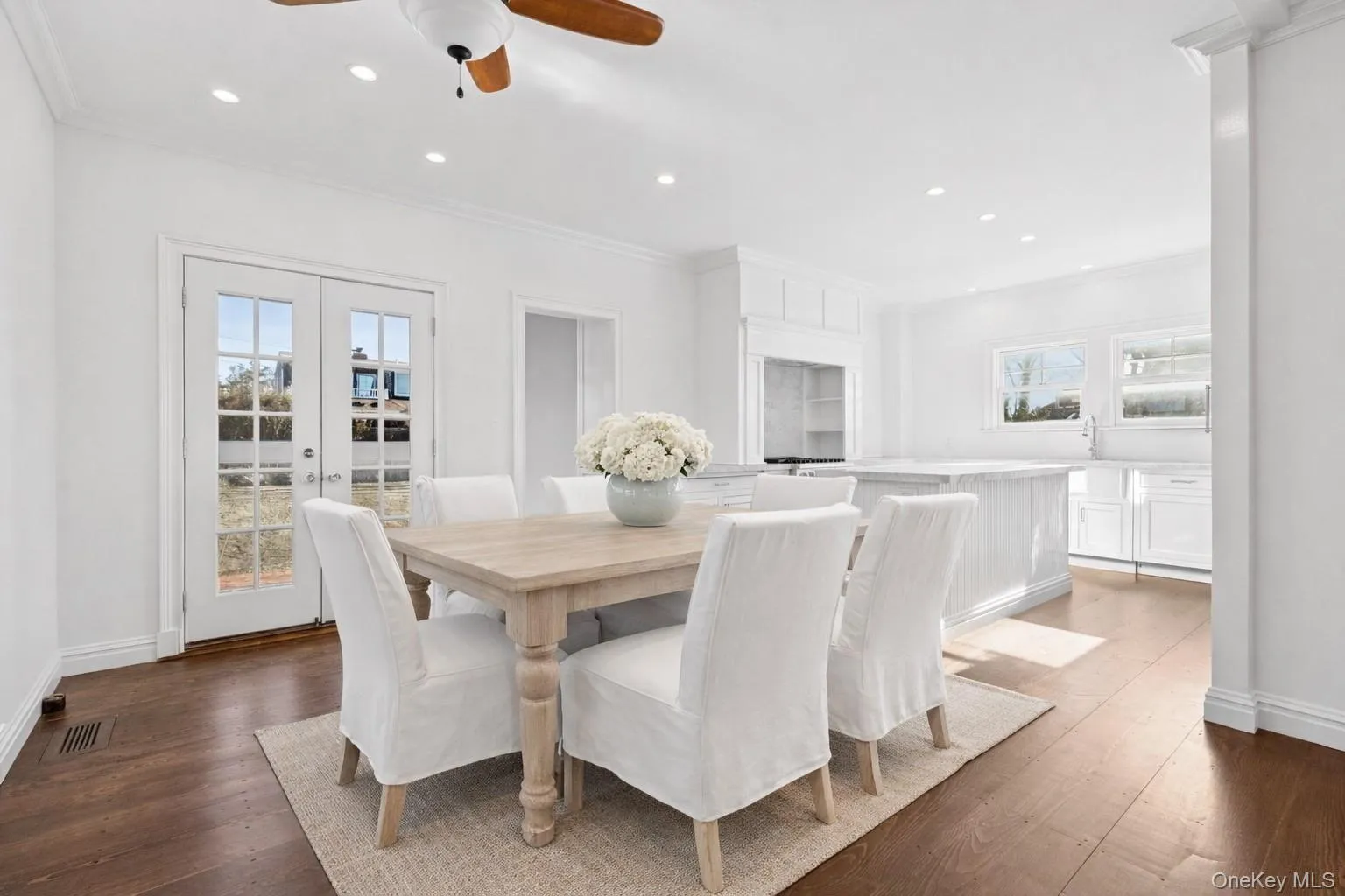 Dining room featuring recessed lighting, crown molding, french doors, dark wood-type flooring, and a ceiling fan Dining room featuring recessed lighting, crown molding, french doors, dark wood-type flooring, and a ceiling fan