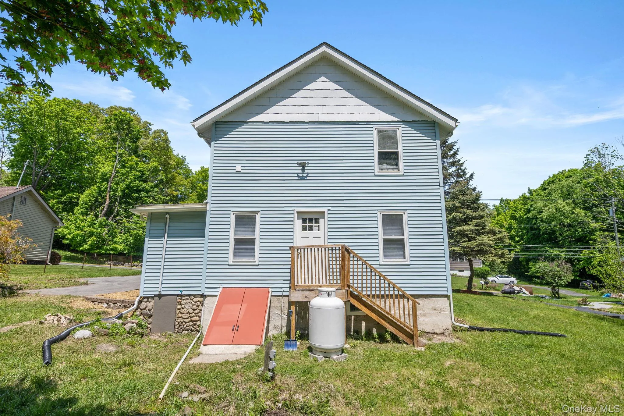 Back of house with a lawn and view of wooded area Back of house with a lawn and view of wooded area