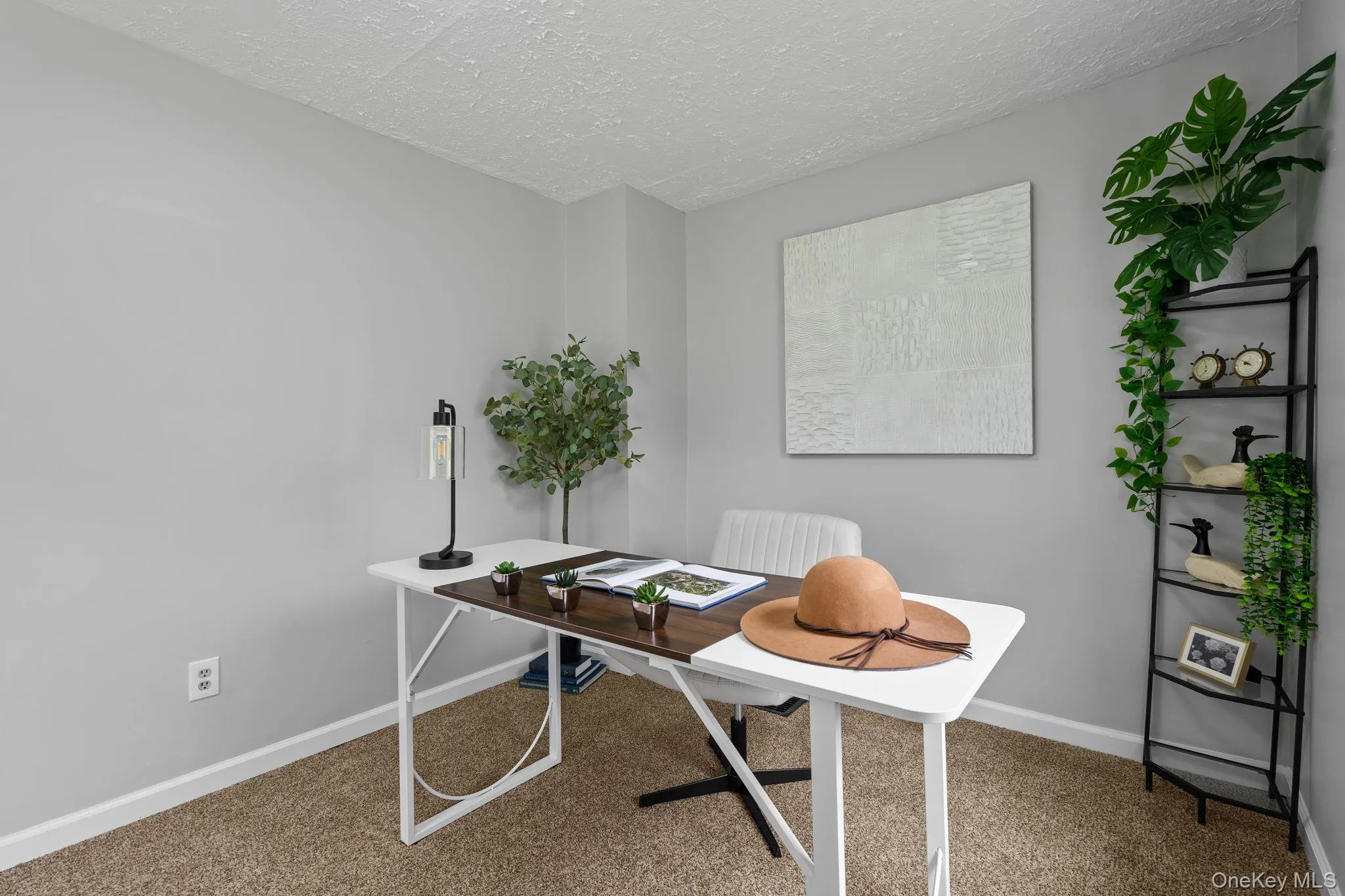 Office area with a textured ceiling and carpet flooring Office area with a textured ceiling and carpet flooring