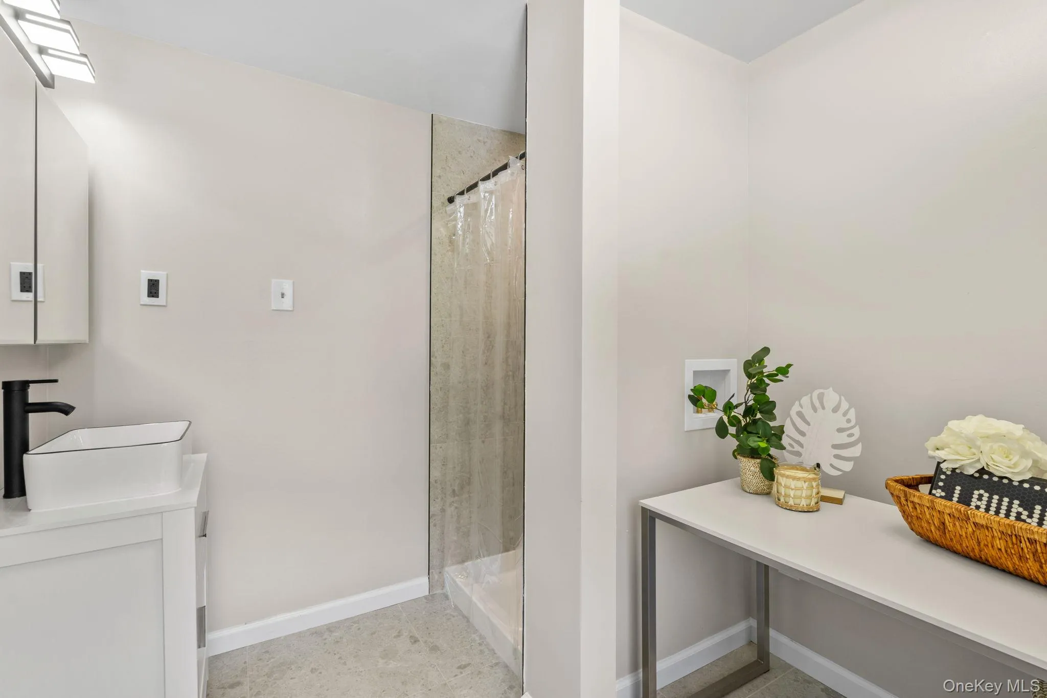 Bathroom featuring vanity, a shower with curtain, and light tile patterned floors Bathroom featuring vanity, a shower with curtain, and light tile patterned floors