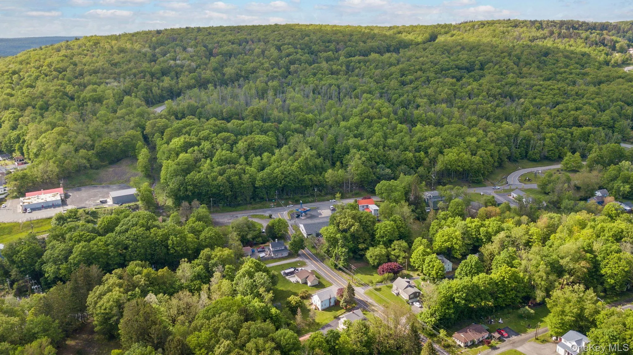 Aerial view of property and surrounding area with a heavily wooded area Aerial view of property and surrounding area with a heavily wooded area