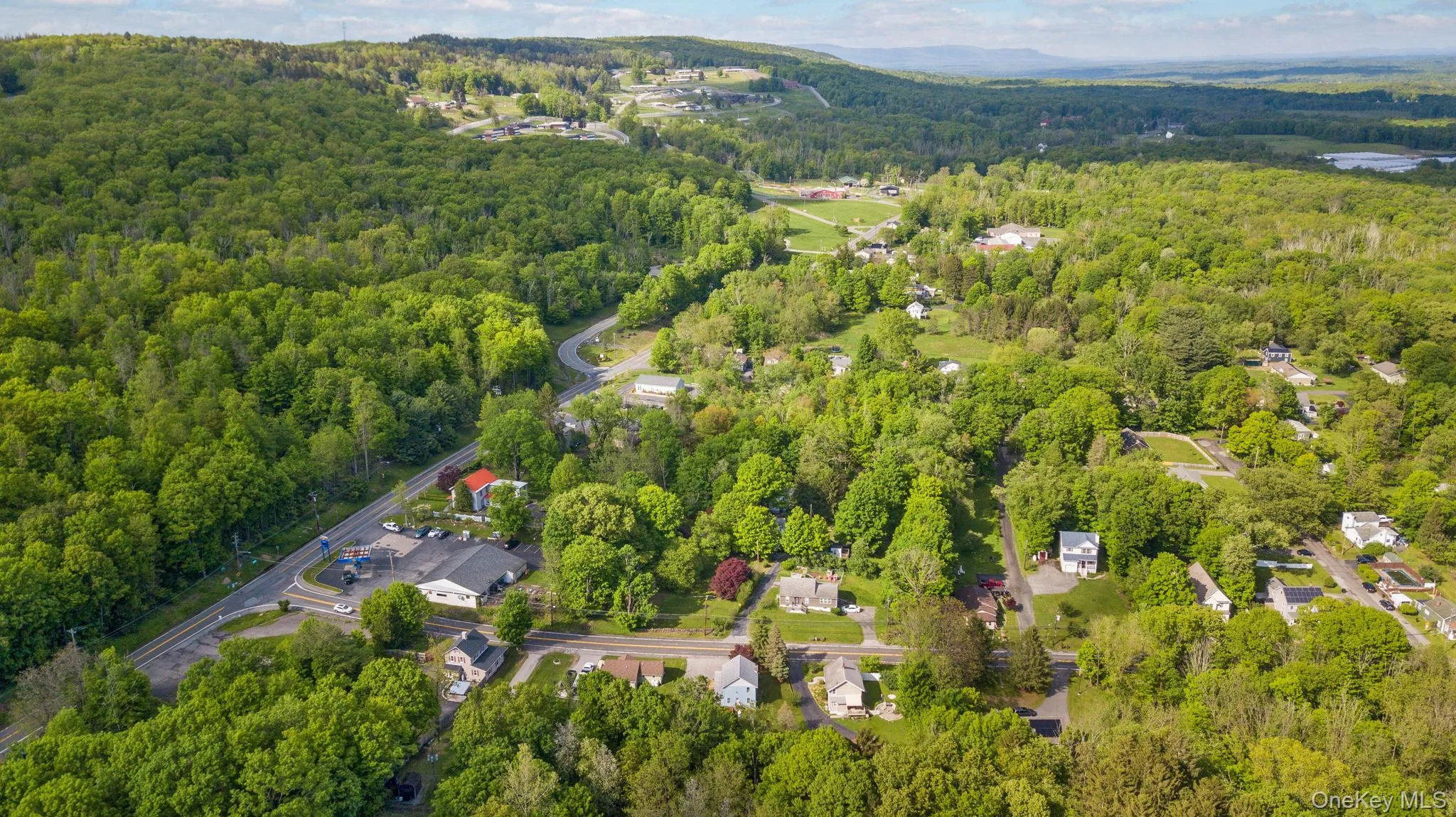 Aerial view of property's location with a forest Aerial view of property's location with a forest