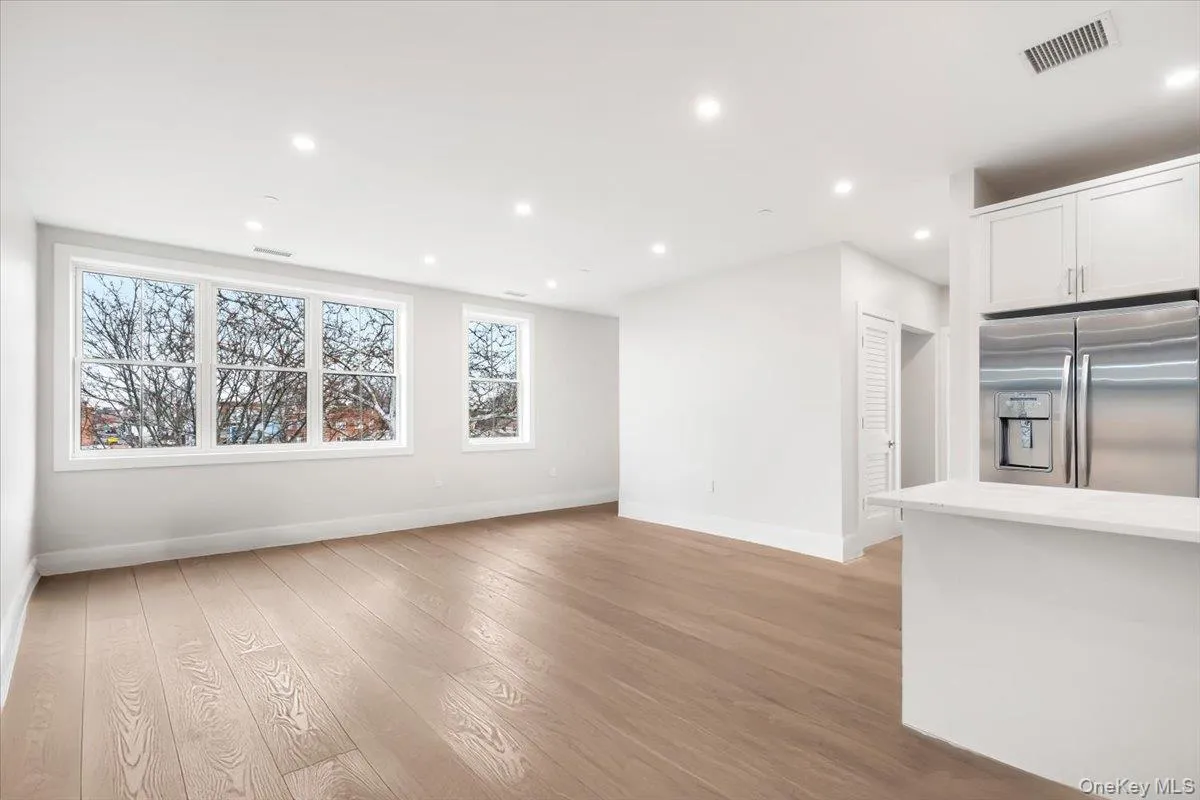 Open large dedicated living space featuring high ceilings, recessed lighting, light oak laminate flooring, large windows. Open large dedicated living space featuring high ceilings, recessed lighting, light oak laminate flooring, large windows.