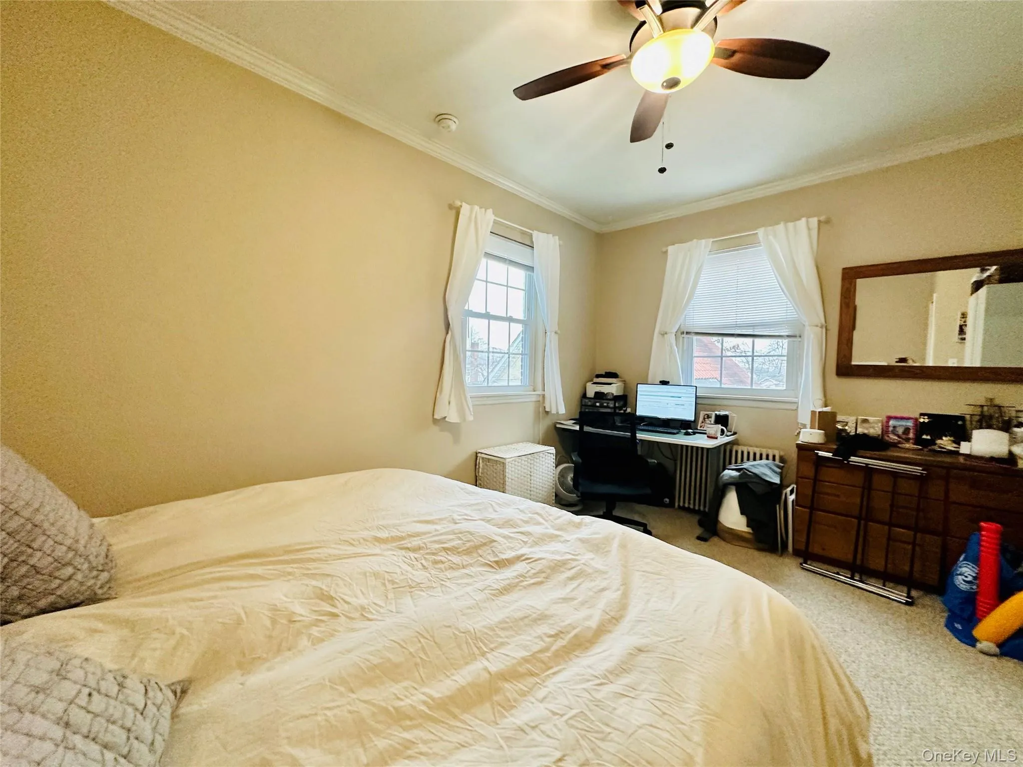 Bedroom featuring ornamental molding, carpet, and ceiling fan Bedroom featuring ornamental molding, carpet, and ceiling fan