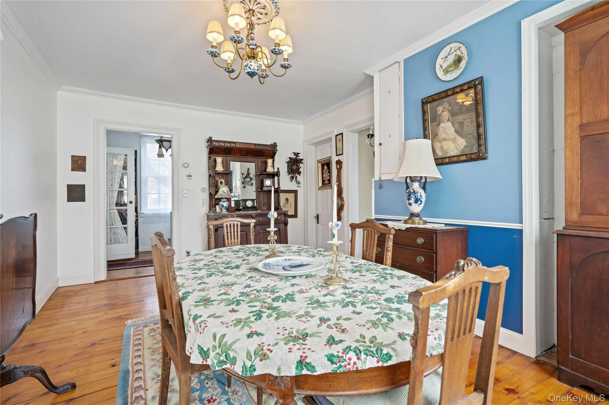 Dining space featuring light wood-style floors, a chandelier, and crown molding Dining space featuring light wood-style floors, a chandelier, and crown molding