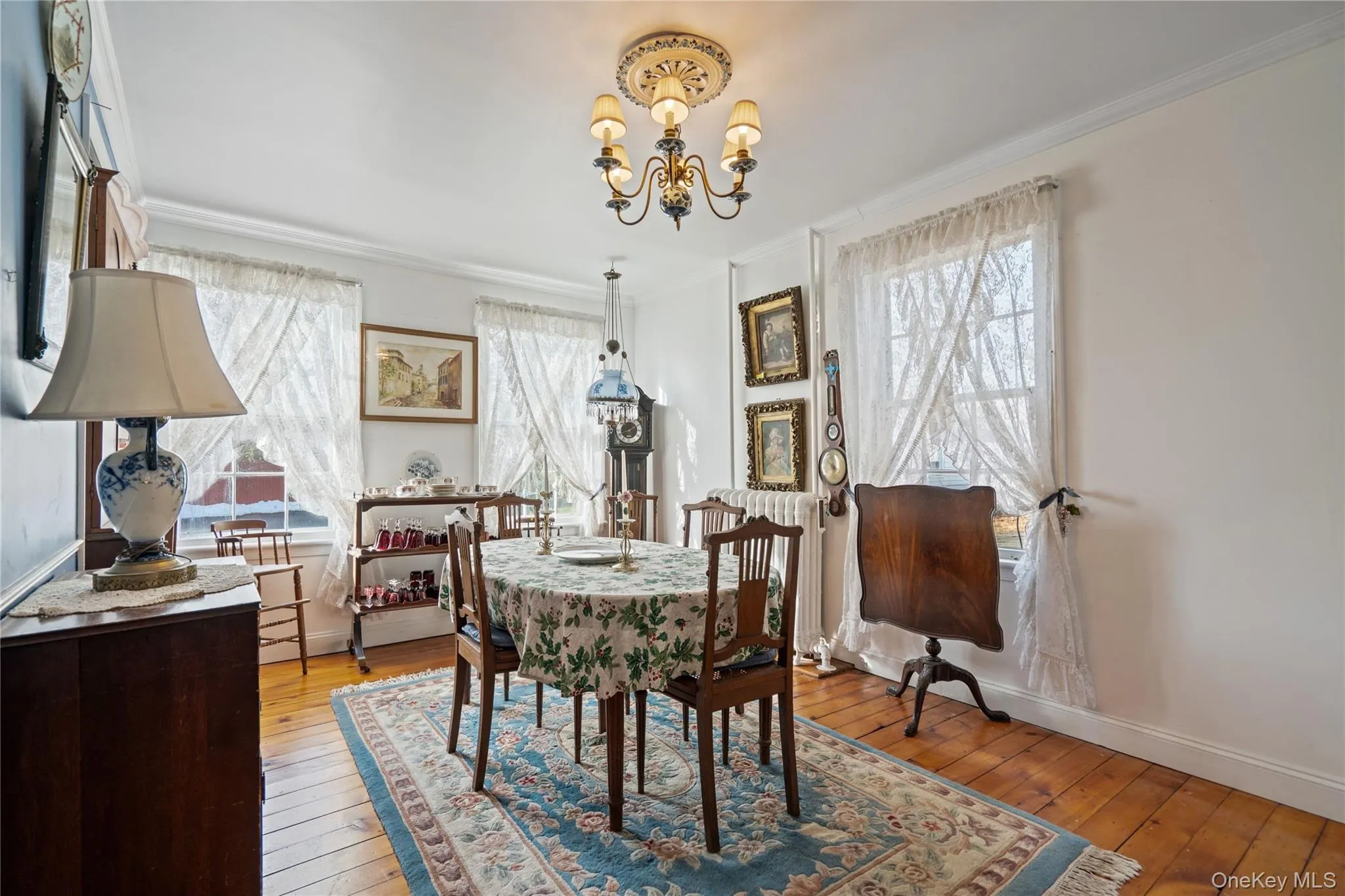 Dining area featuring light wood-style flooring, crown molding, a chandelier, and healthy amount of natural light Dining area featuring light wood-style flooring, crown molding, a chandelier, and healthy amount of natural light