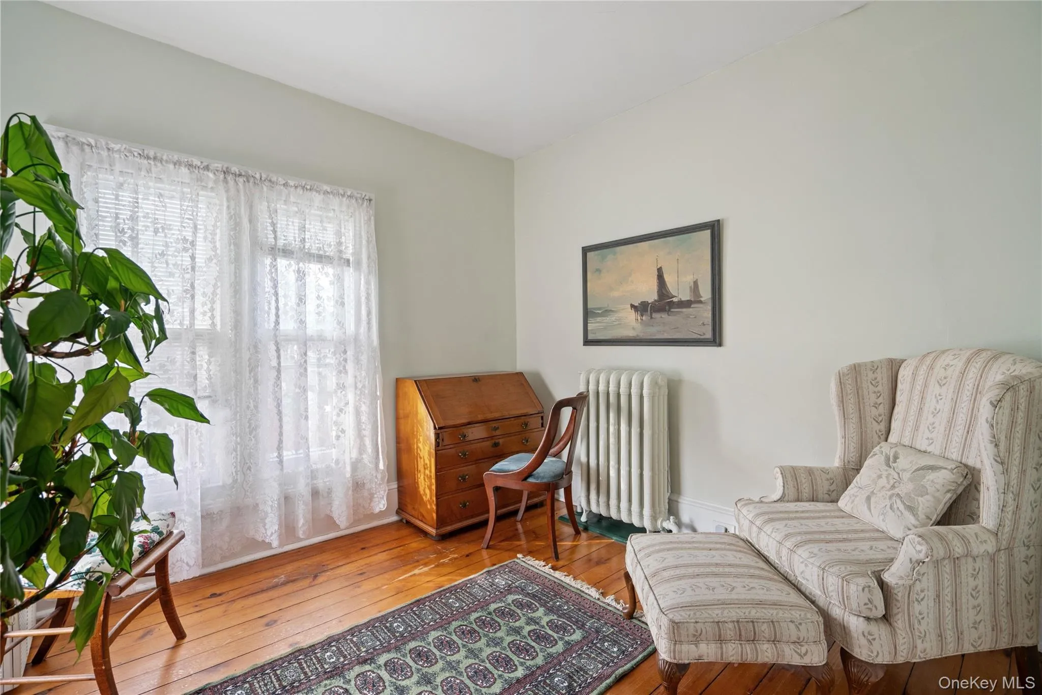 Living area featuring radiator heating unit and hardwood / wood-style floors Living area featuring radiator heating unit and hardwood / wood-style floors