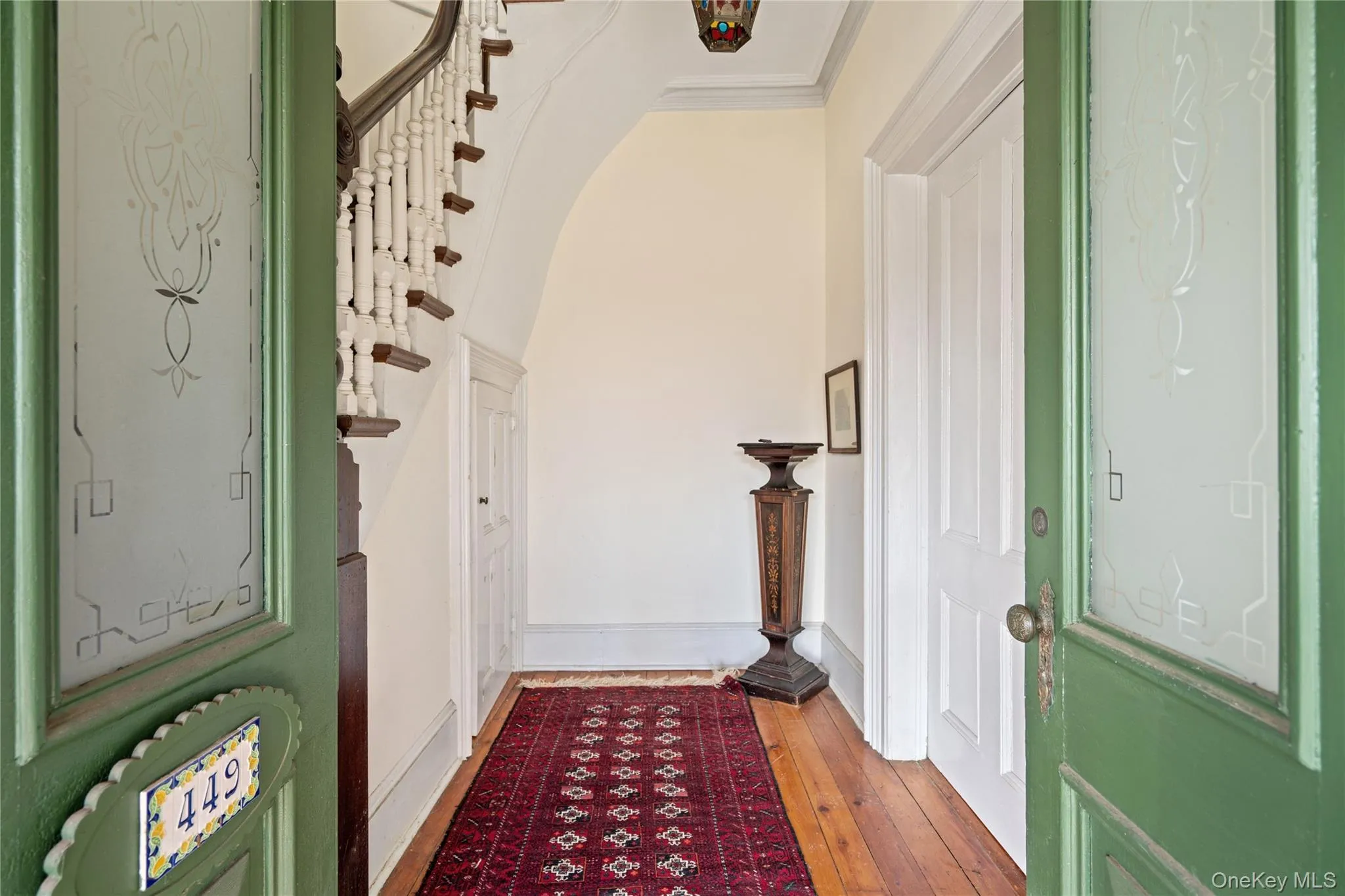 Entryway featuring arched walkways and wood-type flooring Entryway featuring arched walkways and wood-type flooring