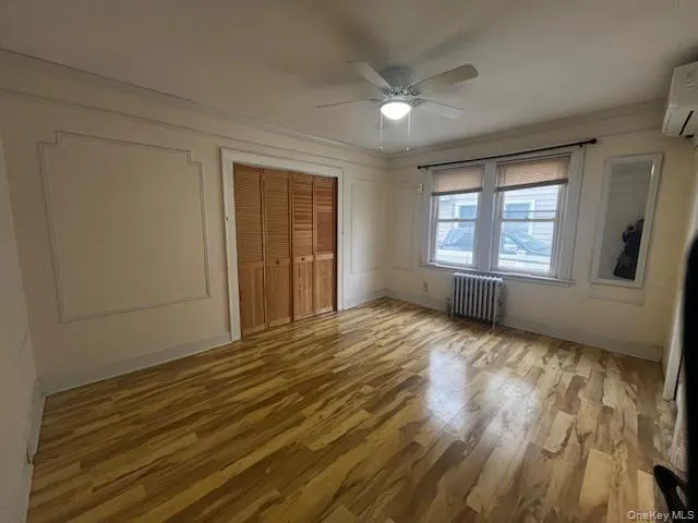 Unfurnished bedroom with light wood finished floors, a closet, radiator heating unit, ceiling fan, and ornamental molding Unfurnished bedroom with light wood finished floors, a closet, radiator heating unit, ceiling fan, and ornamental molding