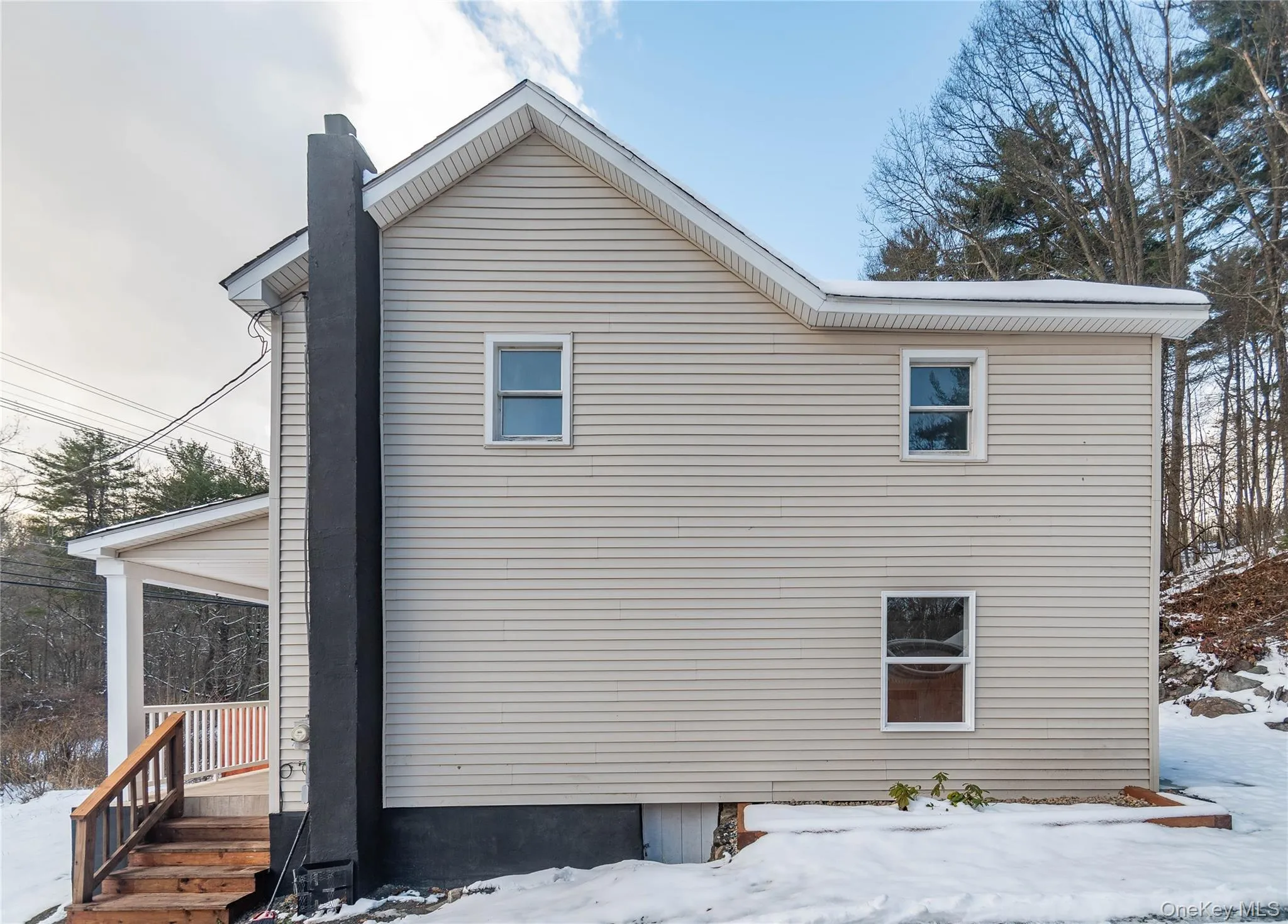 Snow covered property with a chimney and a porch Snow covered property with a chimney and a porch
