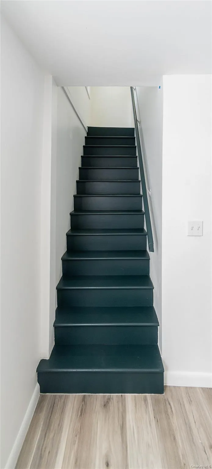 Staircase featuring wood finished floors and baseboards Staircase featuring wood finished floors and baseboards