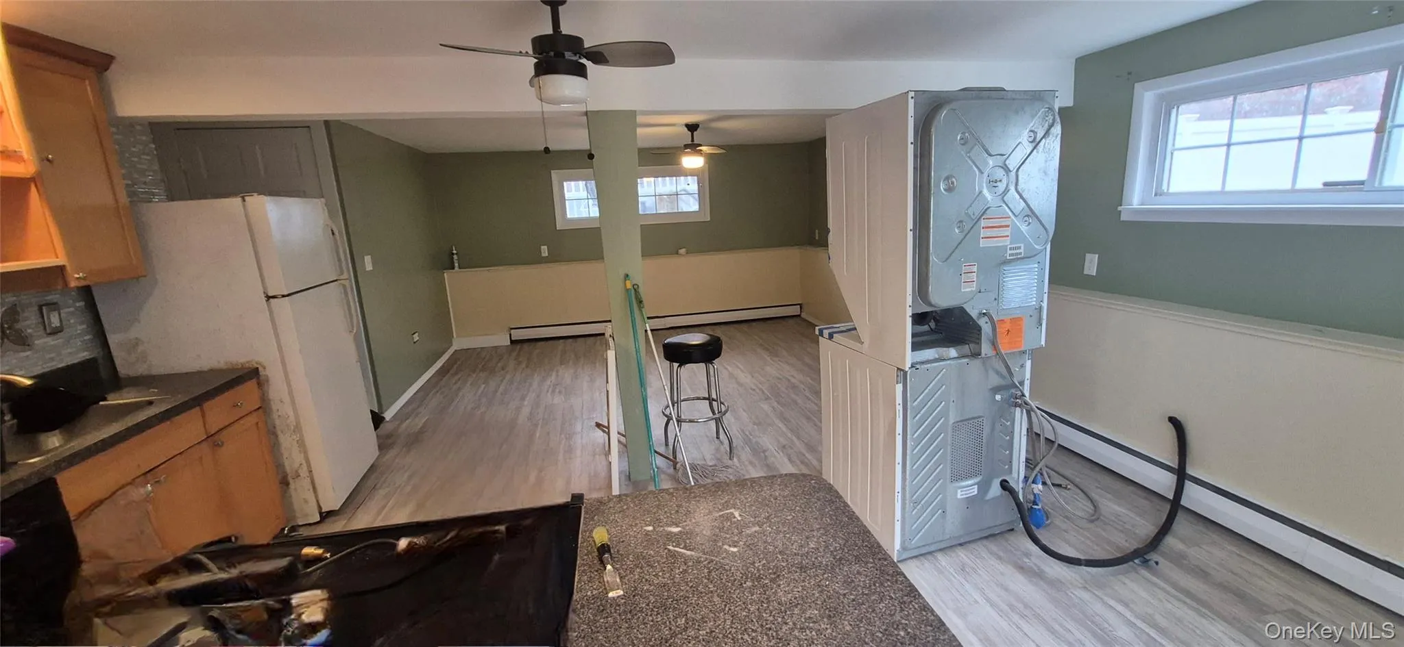 Kitchen with baseboard heating, ceiling fan, light wood-type flooring, and plenty of natural light Kitchen with baseboard heating, ceiling fan, light wood-type flooring, and plenty of natural light