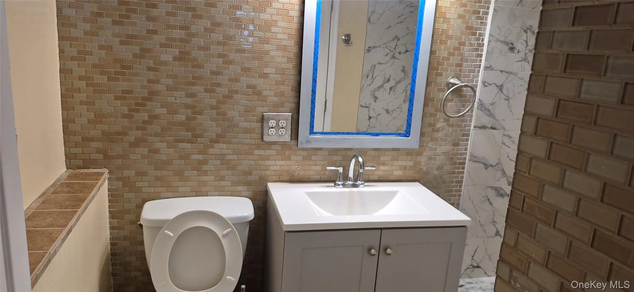 Bathroom featuring vanity and tile walls Bathroom featuring vanity and tile walls