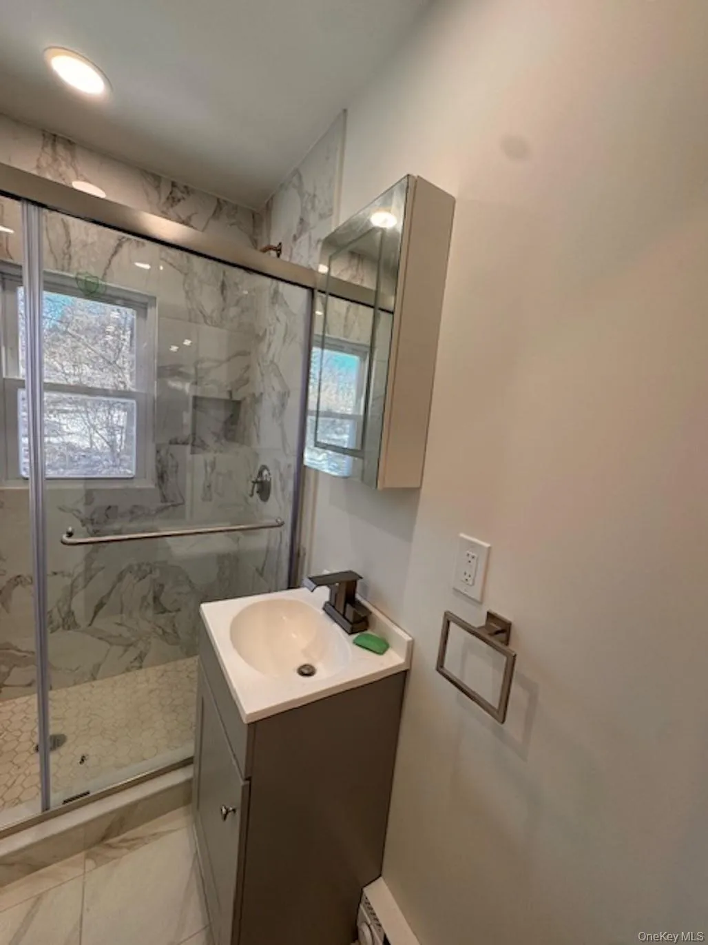 Full bathroom with vanity, a marble finish shower, and light marble finish flooring Full bathroom with vanity, a marble finish shower, and light marble finish flooring