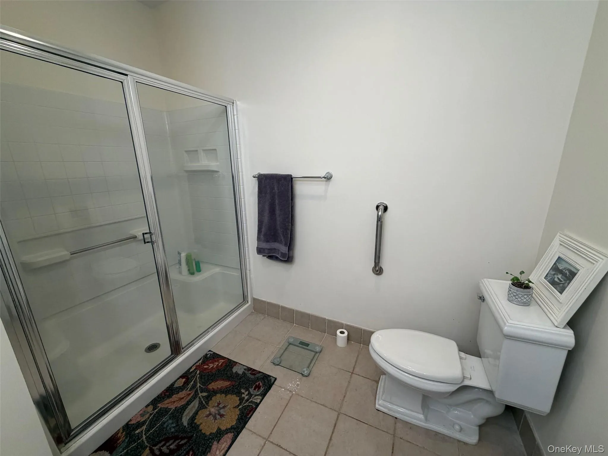 Full bath with a shower stall and light tile patterned floors Full bath with a shower stall and light tile patterned floors