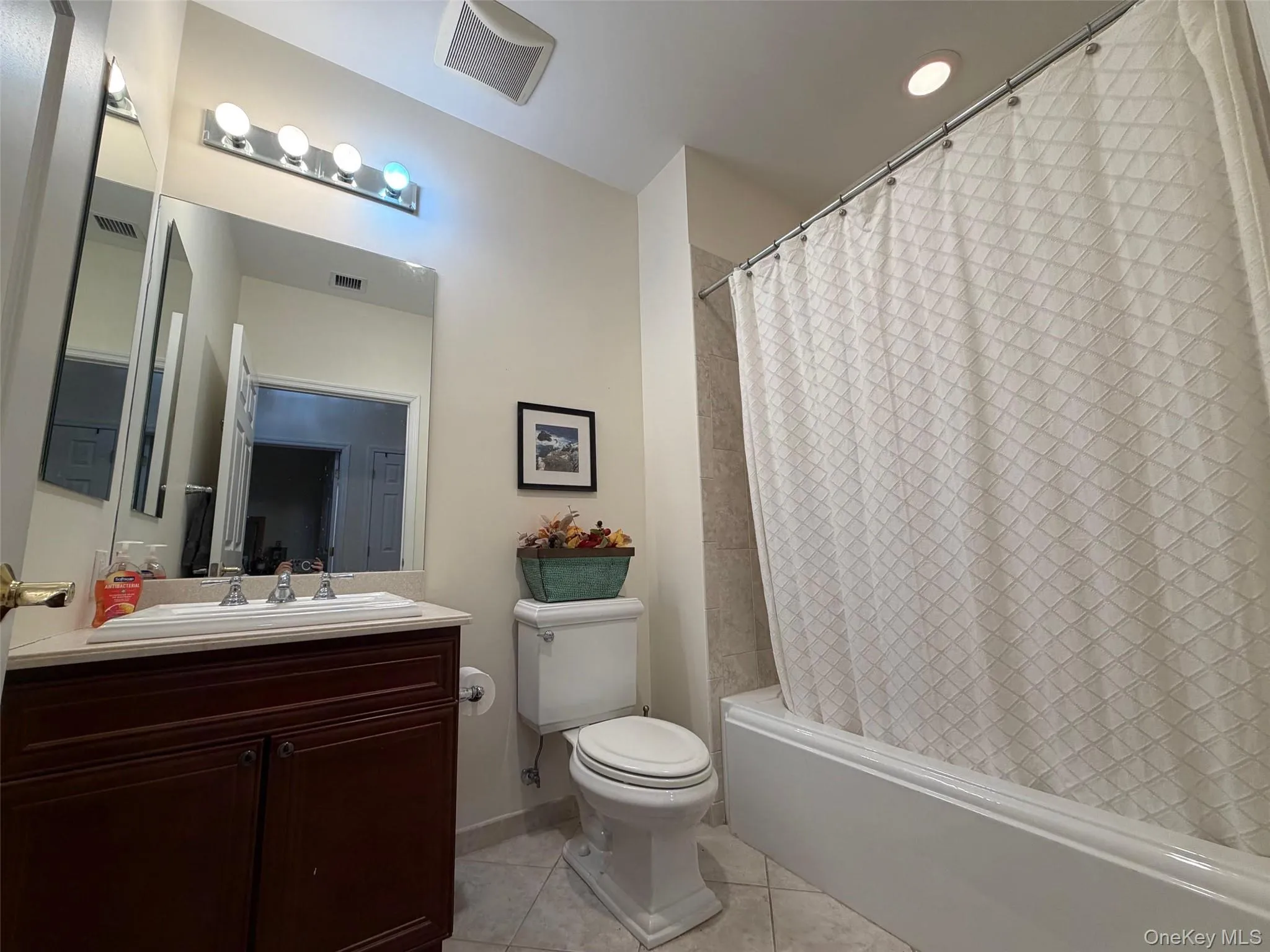 Bathroom with shower / bath combo, light tile patterned floors, vanity, and recessed lighting Bathroom with shower / bath combo, light tile patterned floors, vanity, and recessed lighting