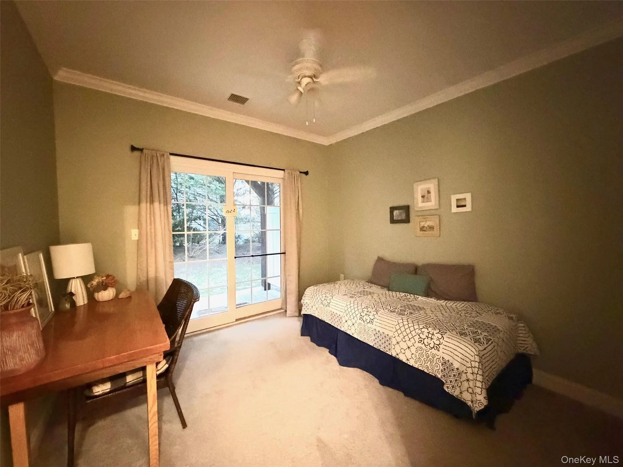 Carpeted bedroom with access to exterior, ornamental molding, and a ceiling fan Carpeted bedroom with access to exterior, ornamental molding, and a ceiling fan