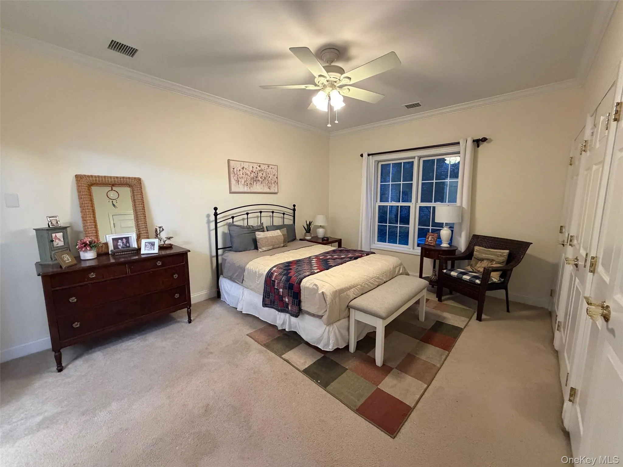 Bedroom featuring ornamental molding, a ceiling fan, and light colored carpet Bedroom featuring ornamental molding, a ceiling fan, and light colored carpet