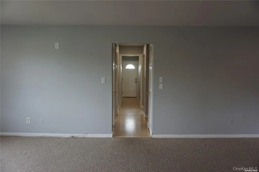 Carpeted empty room featuring baseboards Carpeted empty room featuring baseboards