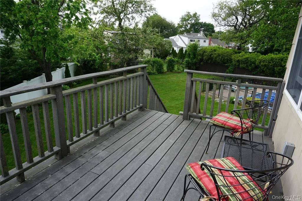 Wooden terrace featuring a yard and view of wooded area Wooden terrace featuring a yard and view of wooded area