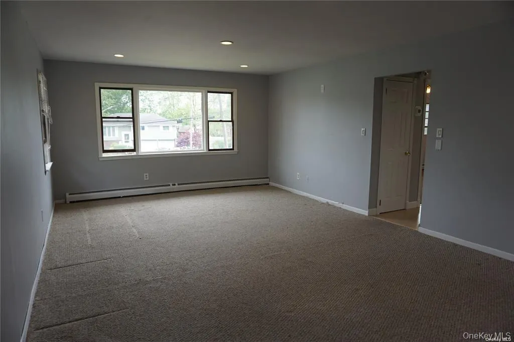 Unfurnished room featuring light carpet, a baseboard heating unit, and recessed lighting Unfurnished room featuring light carpet, a baseboard heating unit, and recessed lighting