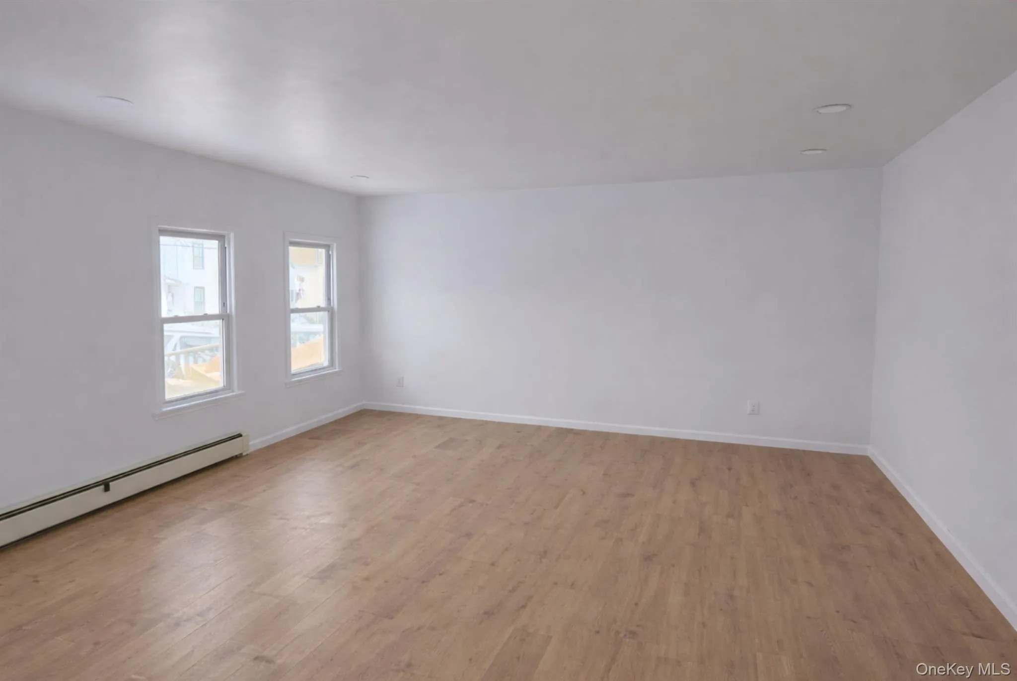 Spare room with light wood-type flooring and baseboards Spare room with light wood-type flooring and baseboards