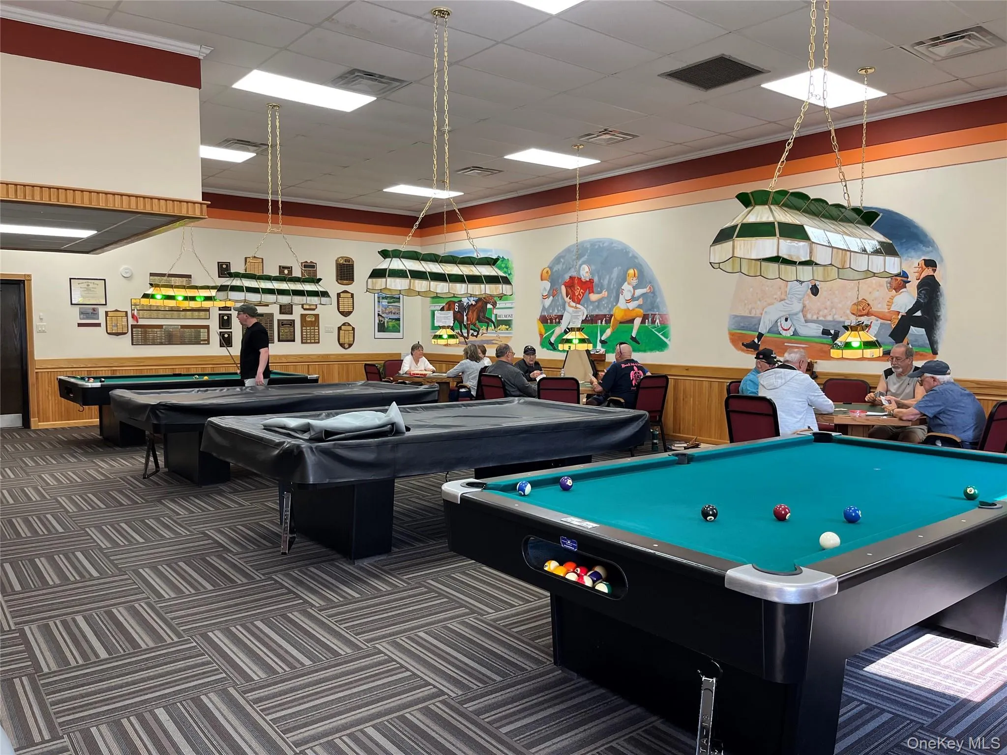 Playroom featuring pool table, wainscoting, a paneled ceiling, and wood walls Playroom featuring pool table, wainscoting, a paneled ceiling, and wood walls