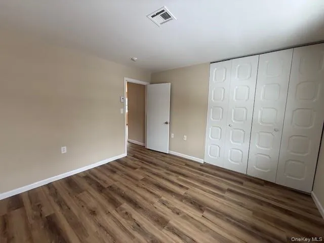 Unfurnished bedroom featuring a closet and New wood-style flooring Unfurnished bedroom featuring a closet and New wood-style flooring