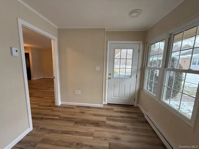 Sunroom with Doorway to outside New wood finished floors, and crown molding Sunroom with Doorway to outside New wood finished floors, and crown molding