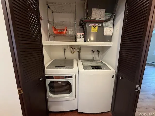 Washroom with Newer Washing Machine and Dryer and Wood Finished Floors Washroom with Newer Washing Machine and Dryer and Wood Finished Floors