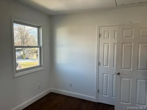 Unfurnished bedroom featuring dark wood-type flooring and baseboards Unfurnished bedroom featuring dark wood-type flooring and baseboards