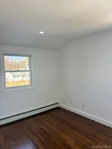 Spare room featuring a baseboard radiator, dark wood finished floors, and recessed lighting Spare room featuring a baseboard radiator, dark wood finished floors, and recessed lighting