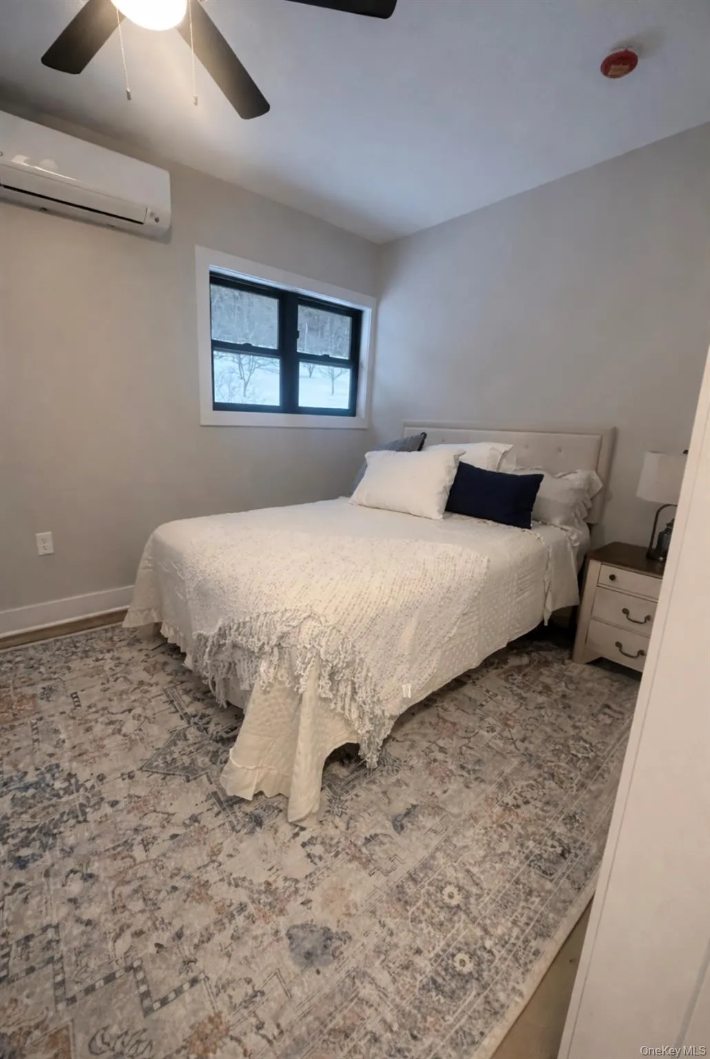 Bedroom with a wall mounted AC and a ceiling fan Bedroom with a wall mounted AC and a ceiling fan