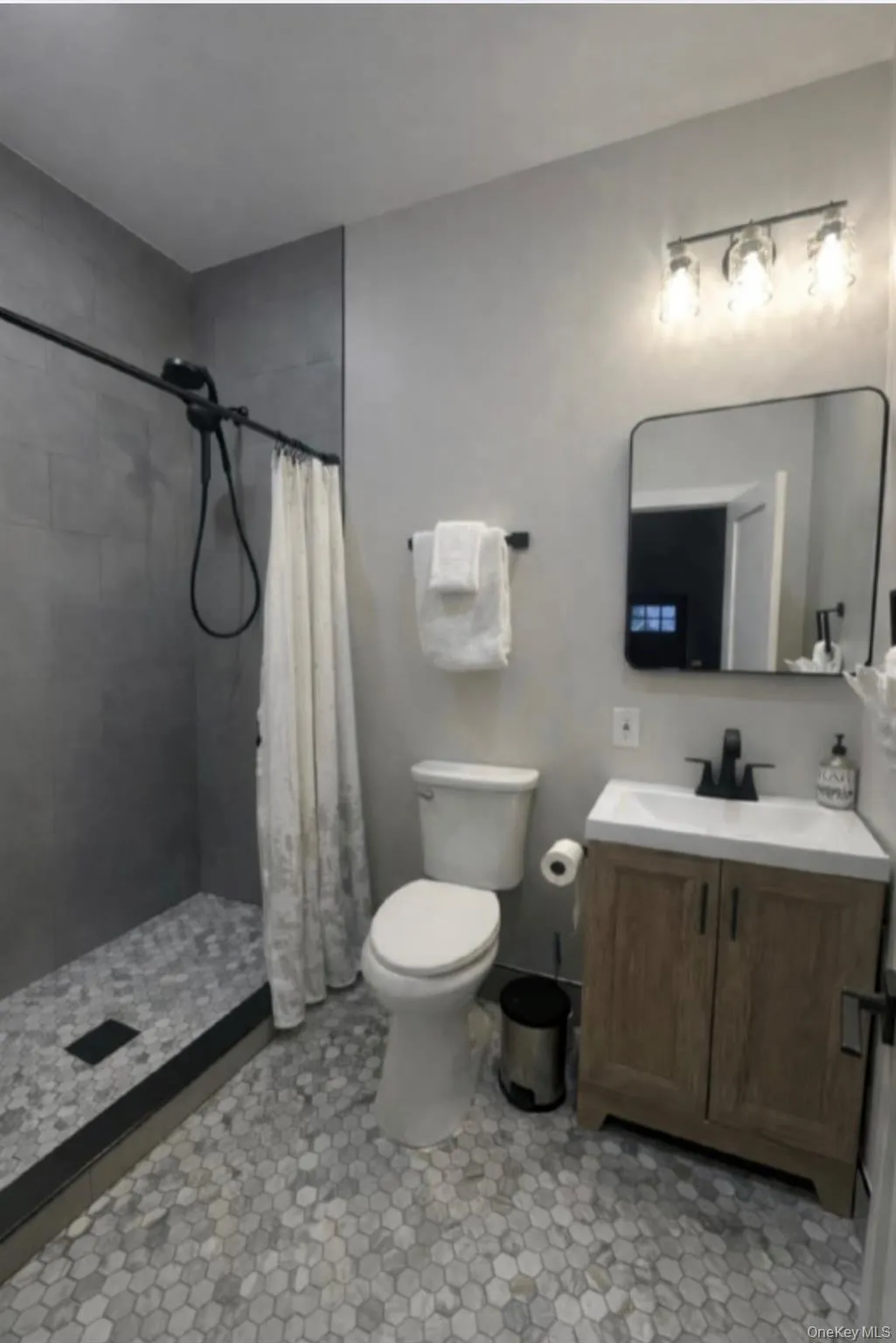 Full bathroom featuring a shower stall and vanity Full bathroom featuring a shower stall and vanity