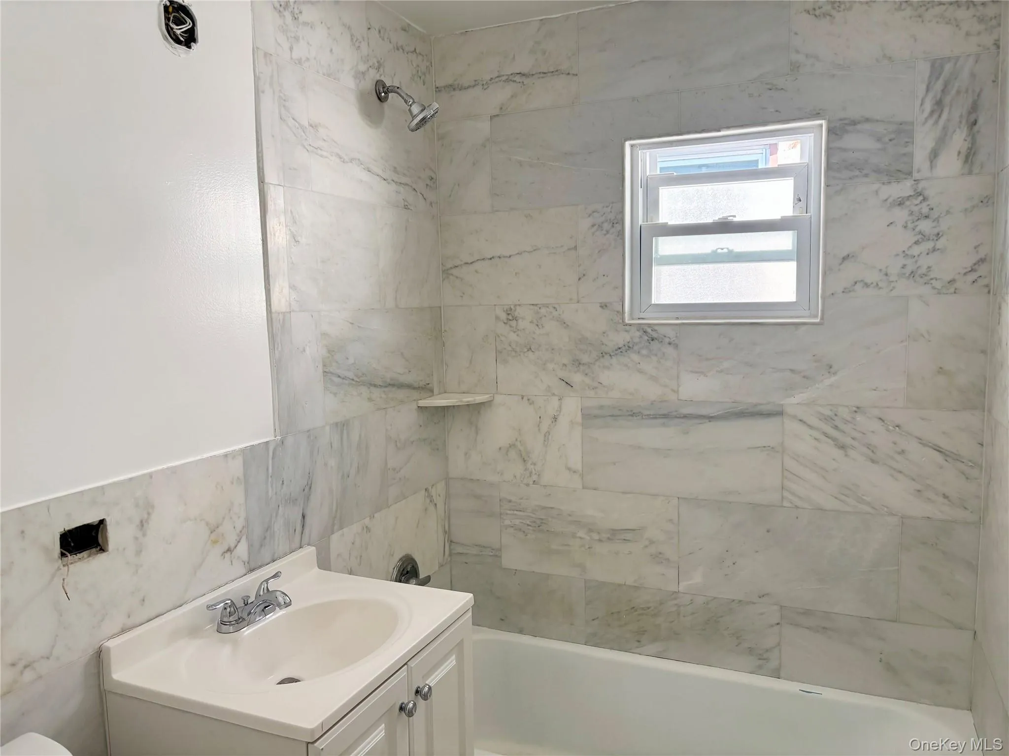Bathroom with shower / washtub combination, vanity, and tile walls Bathroom with shower / washtub combination, vanity, and tile walls