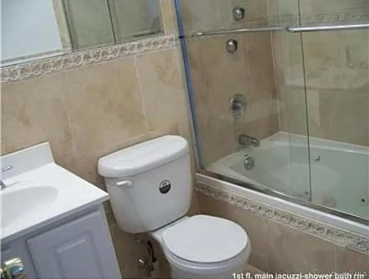 Full bath with tiled shower / bath combo, vanity, and tile walls Full bath with tiled shower / bath combo, vanity, and tile walls