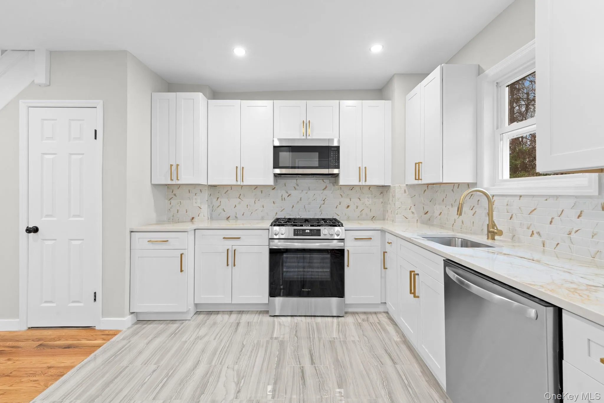 Kitchen with stainless steel appliances, white cabinetry, light stone counters, tasteful backsplash, and recessed lighting Kitchen with stainless steel appliances, white cabinetry, light stone counters, tasteful backsplash, and recessed lighting