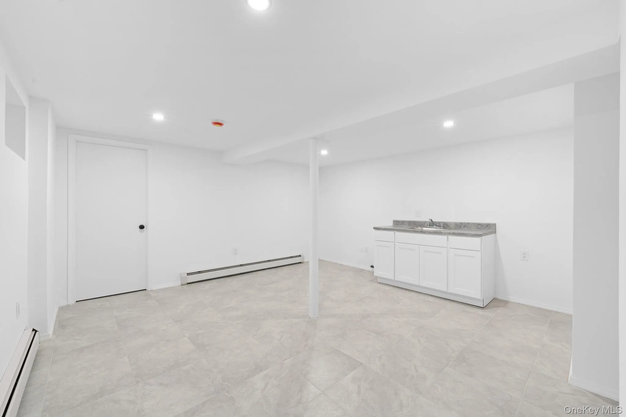 Finished below grade area featuring baseboard heating and recessed lighting Finished below grade area featuring baseboard heating and recessed lighting