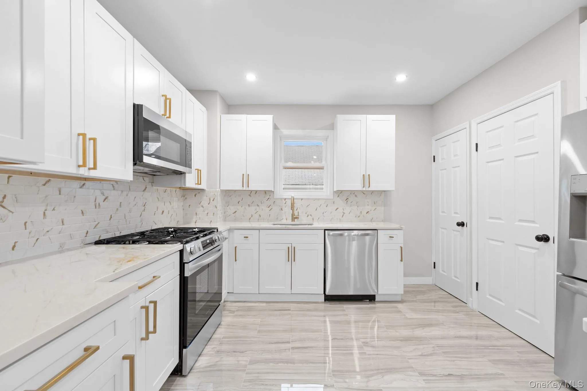Kitchen featuring appliances with stainless steel finishes, light stone countertops, white cabinets, backsplash, and recessed lighting Kitchen featuring appliances with stainless steel finishes, light stone countertops, white cabinets, backsplash, and recessed lighting