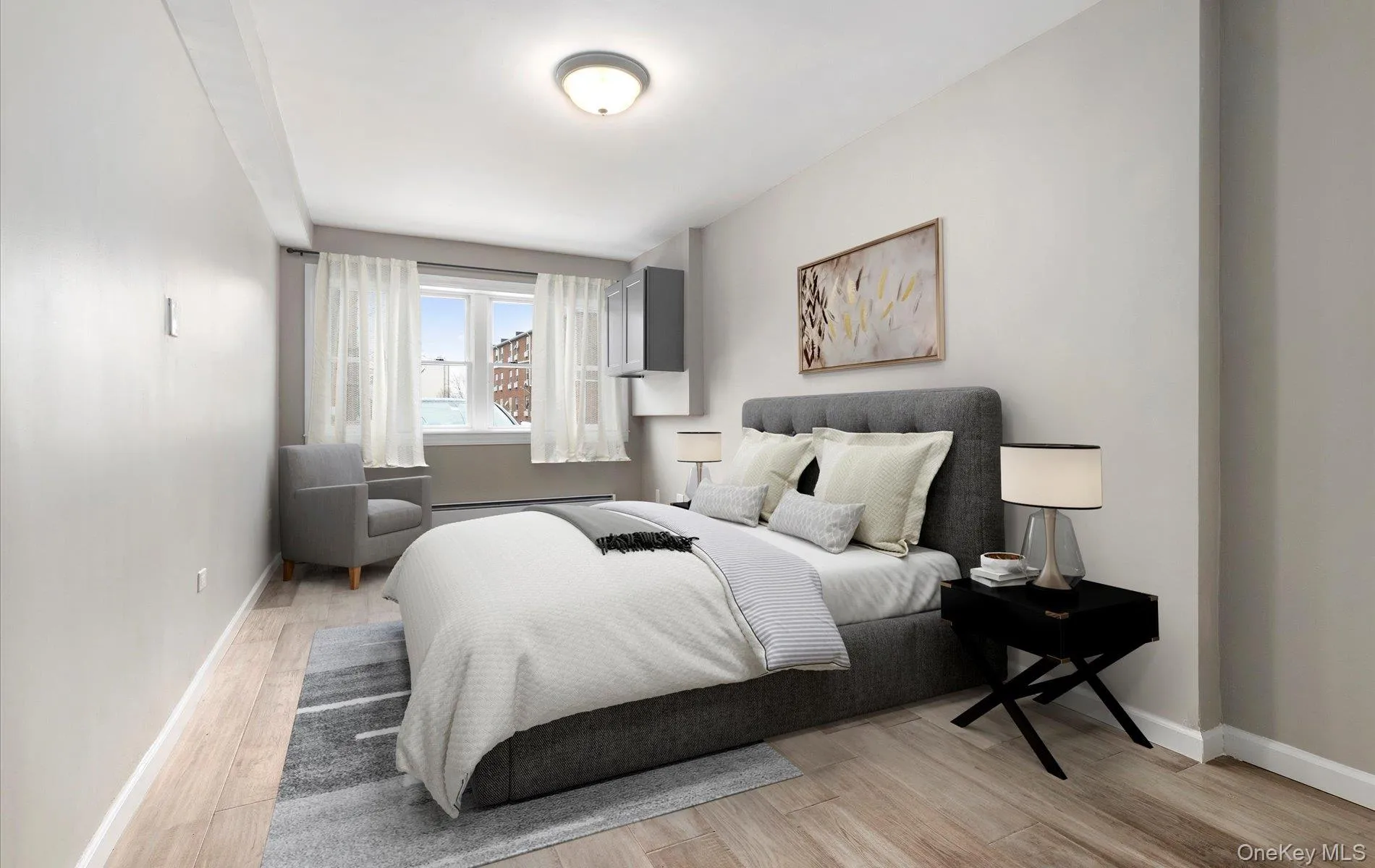 Bedroom featuring light wood-style flooring and a baseboard heating unit Bedroom featuring light wood-style flooring and a baseboard heating unit