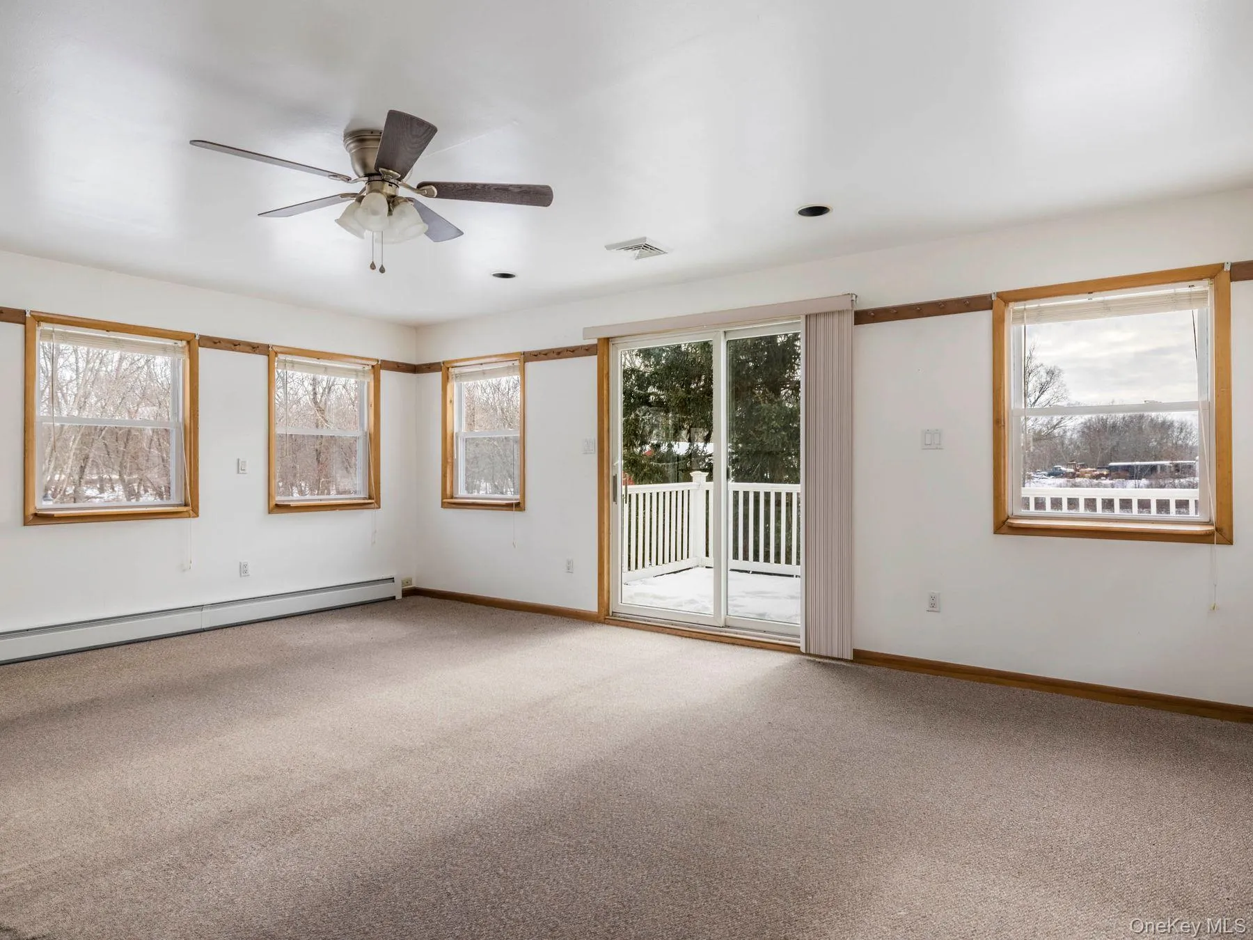 Empty room with carpet floors, a baseboard radiator, and a ceiling fan Empty room with carpet floors, a baseboard radiator, and a ceiling fan