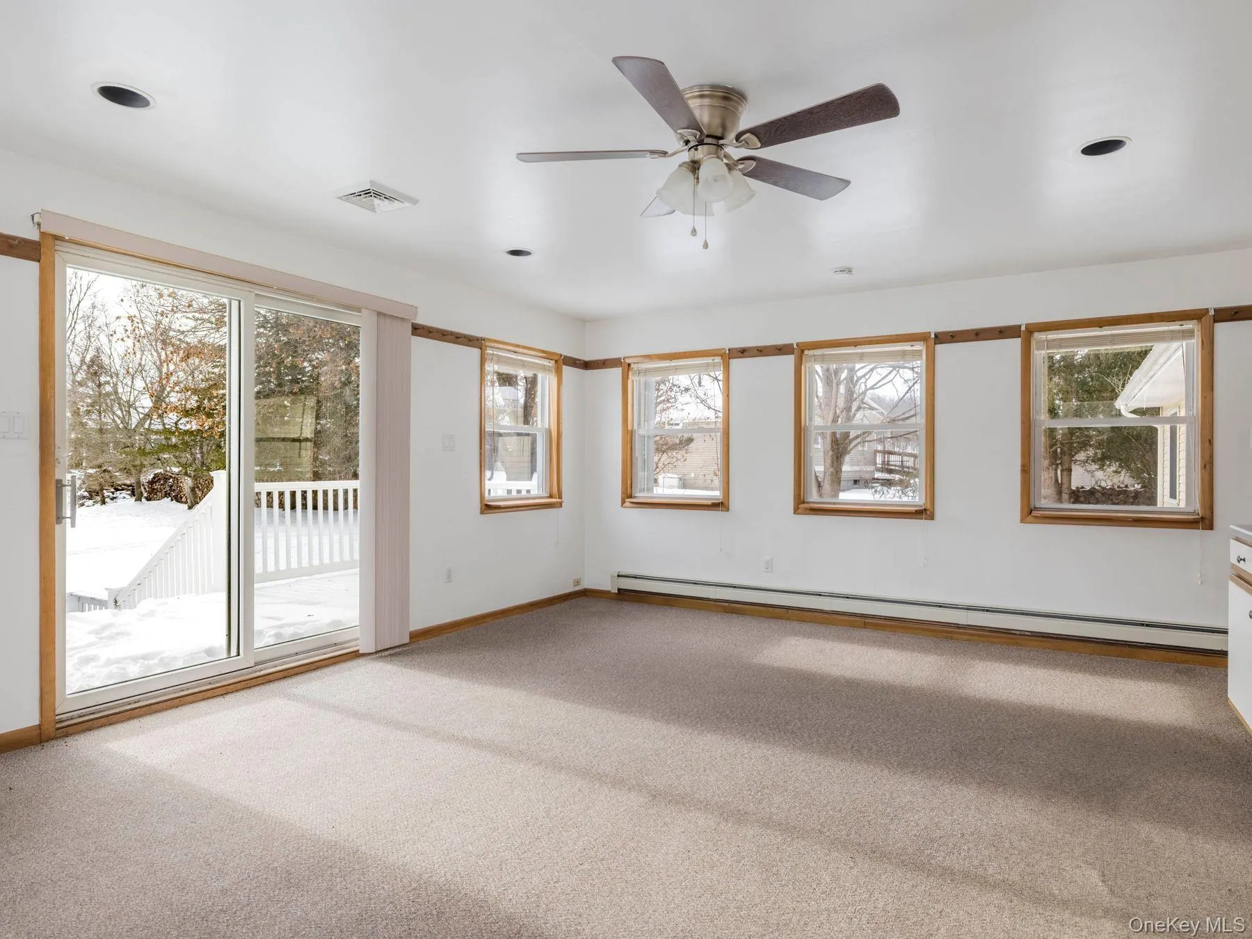 Empty room featuring carpet, a baseboard radiator, and a ceiling fan Empty room featuring carpet, a baseboard radiator, and a ceiling fan