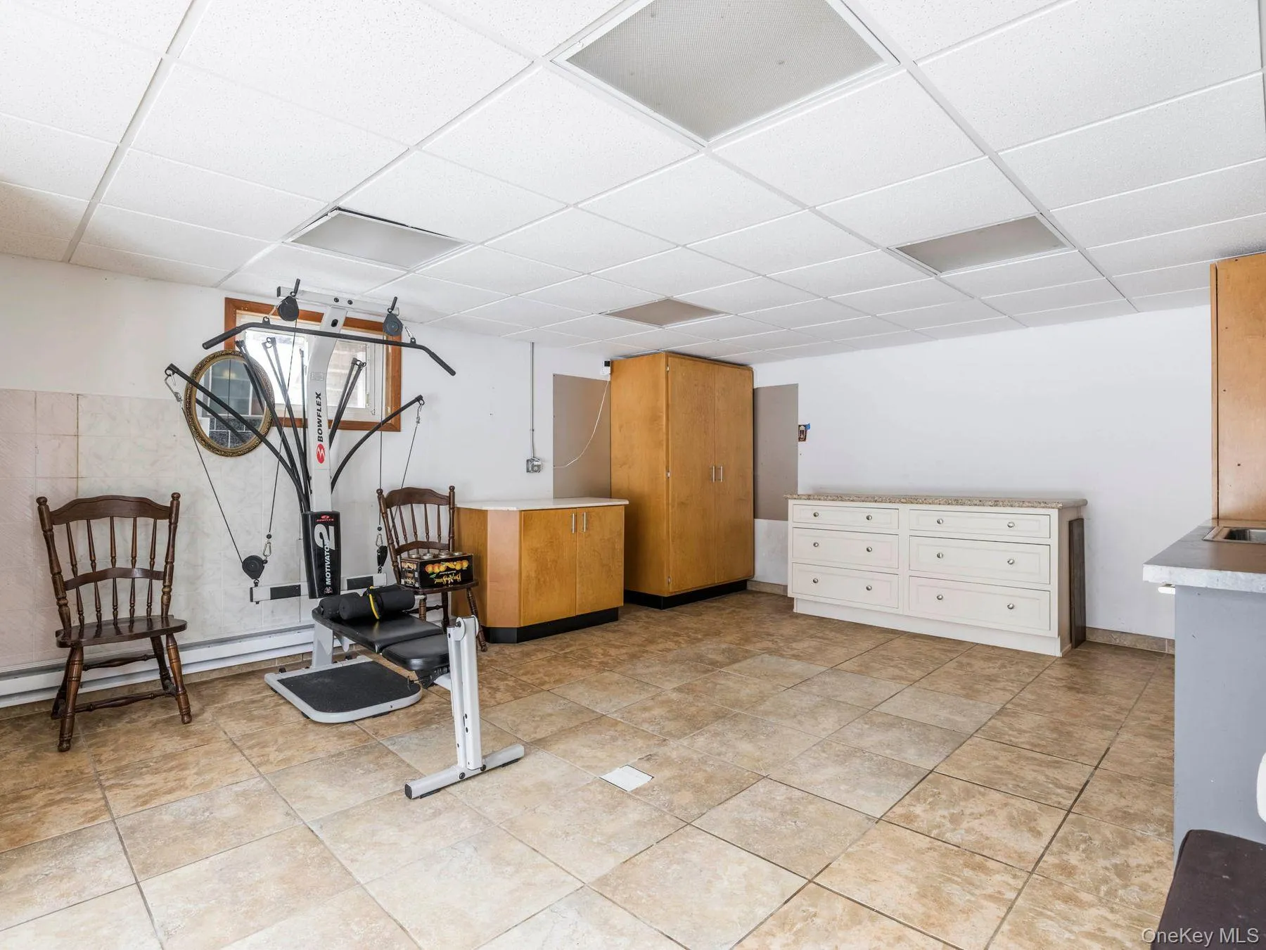 Workout room featuring a paneled ceiling and a baseboard radiator Workout room featuring a paneled ceiling and a baseboard radiator