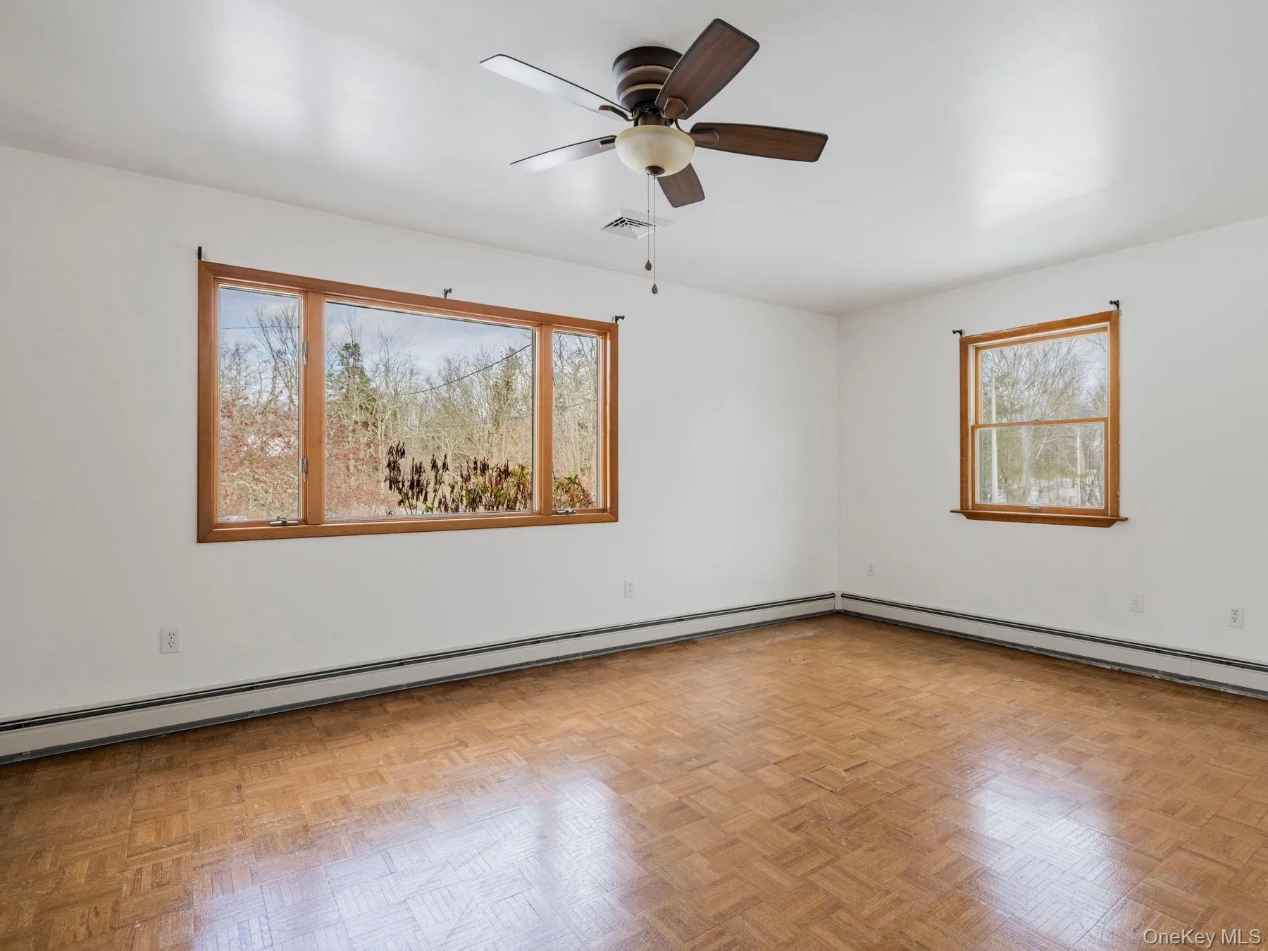 Empty room featuring a baseboard radiator and a ceiling fan Empty room featuring a baseboard radiator and a ceiling fan