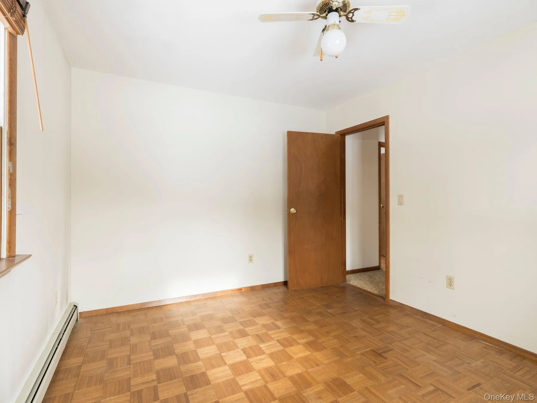 Empty room with a baseboard heating unit and ceiling fan Empty room with a baseboard heating unit and ceiling fan