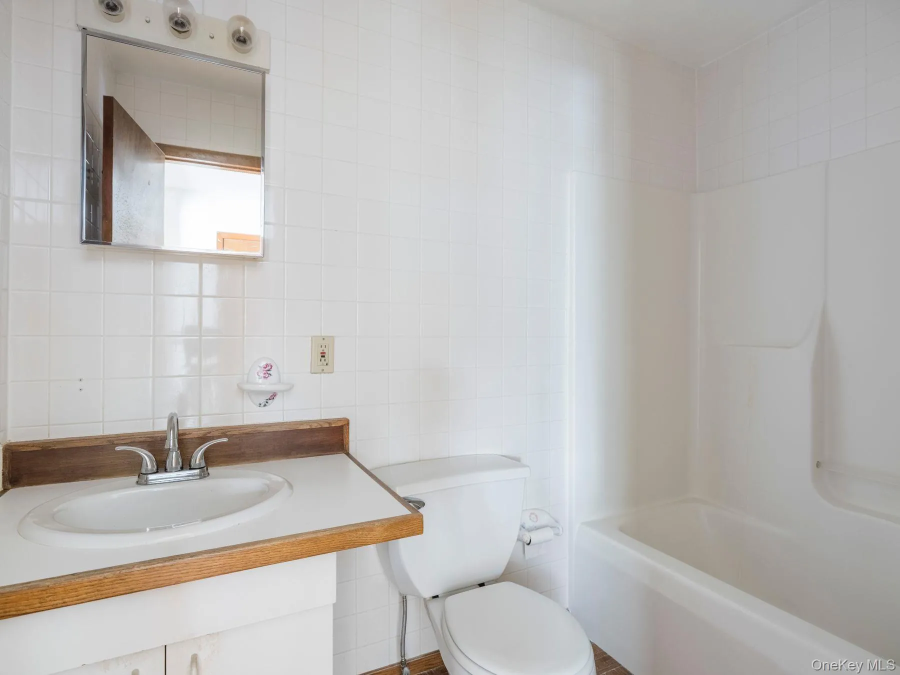 Bathroom featuring tile walls, vanity, and bathtub / shower combination Bathroom featuring tile walls, vanity, and bathtub / shower combination